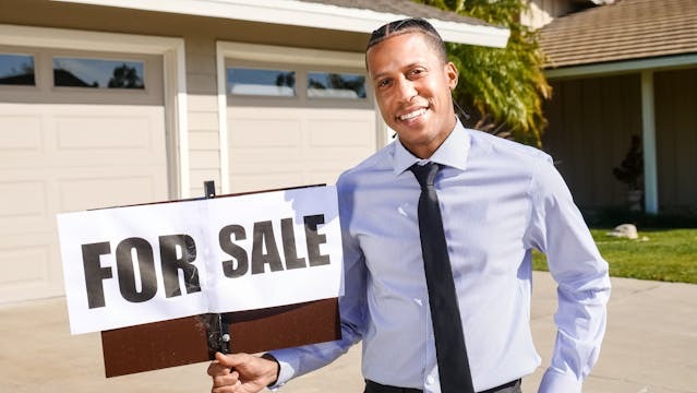 person holding a  for sale sign