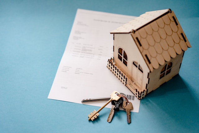 house figurine and keys on top of a leasing document