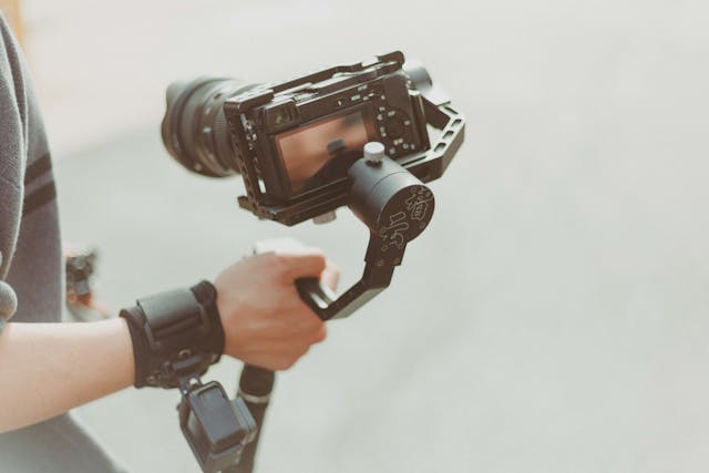 person holding a tripod connected to a camera